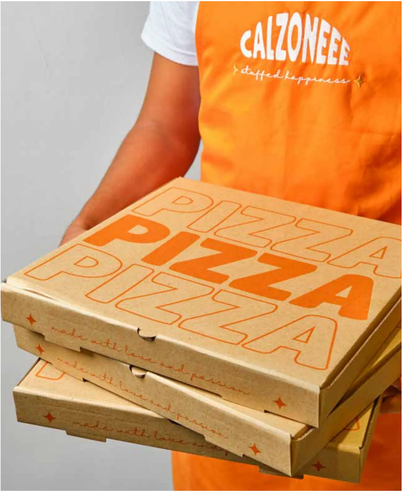 Staff member carrying stacked pizza boxes