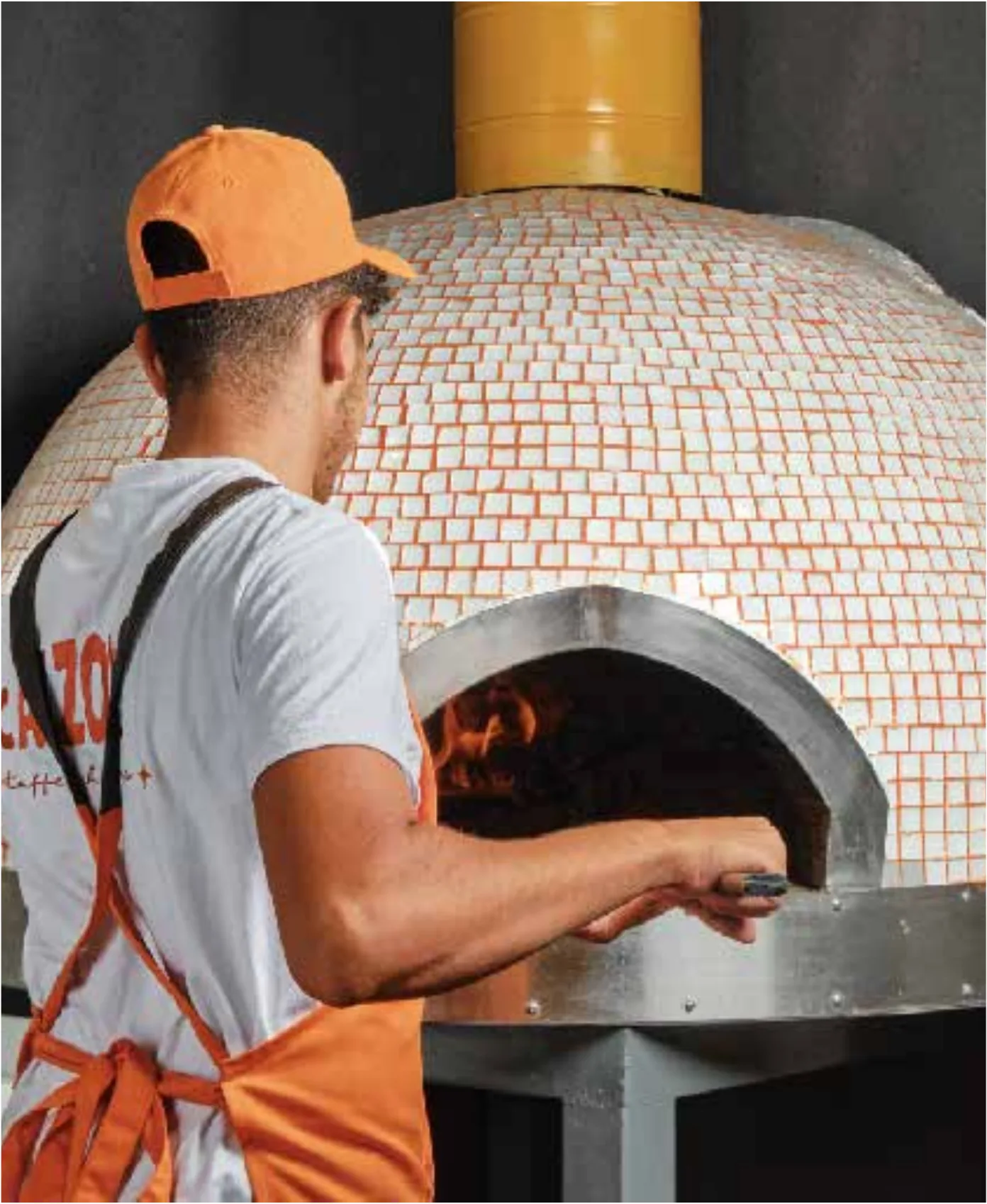 Pizzaiolo working at the wood-fired oven