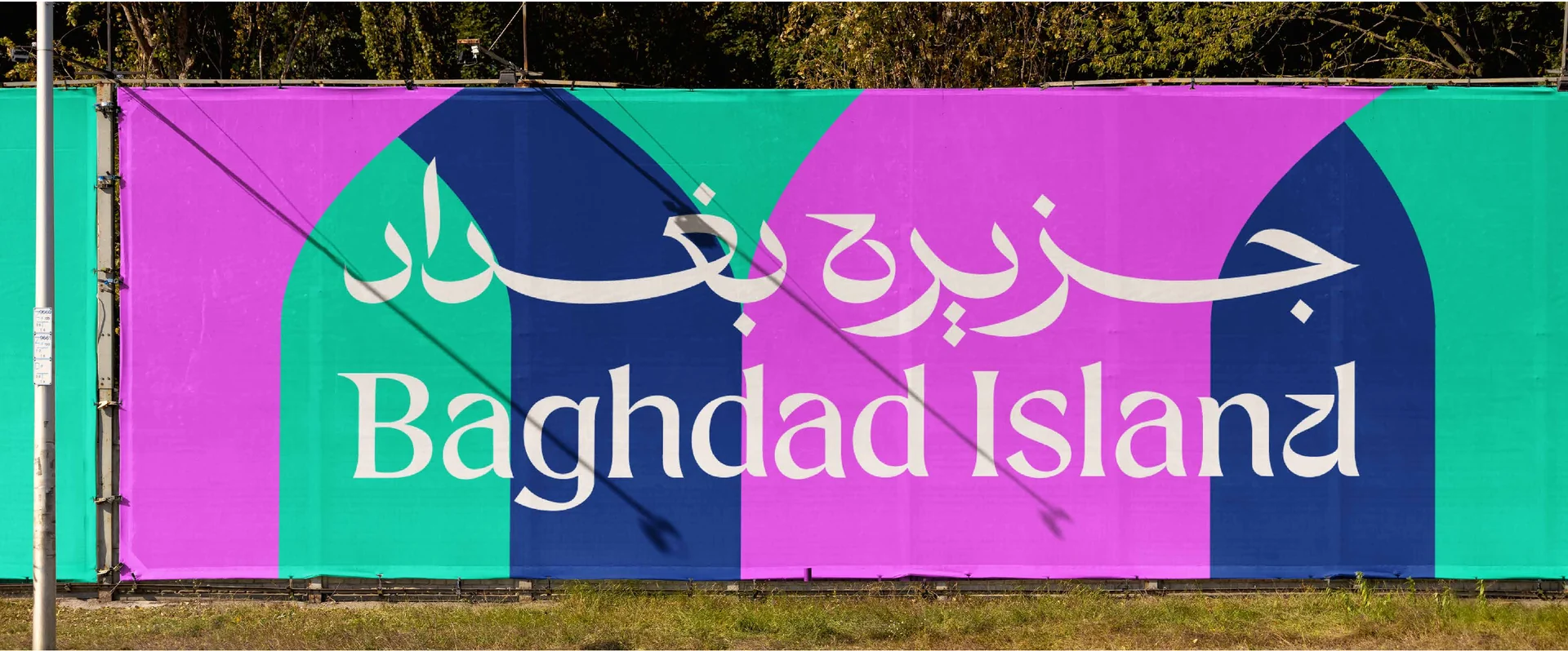 Large outdoor banner with the Baghdad Island bilingual wordmark