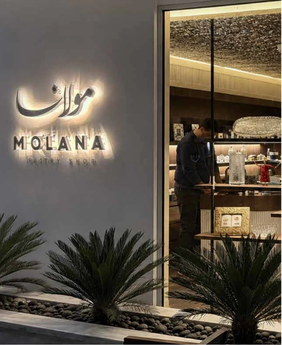 Illuminated Molana signage above the pastry display