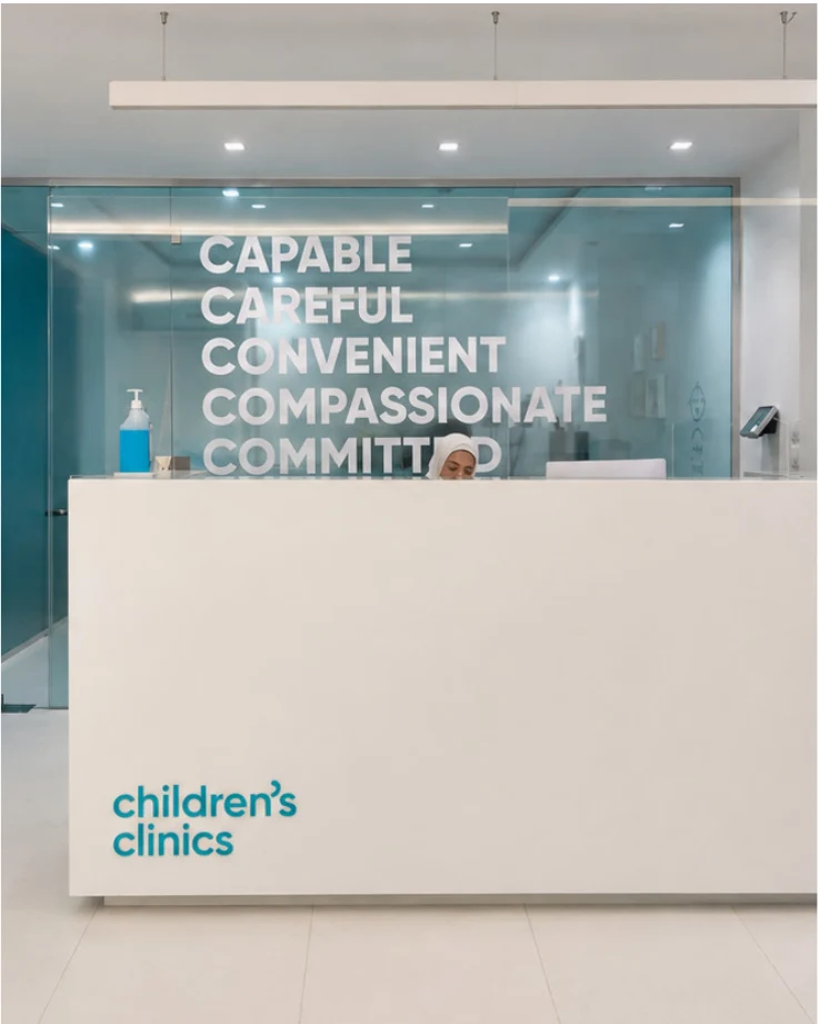 Clinic reception desk with the brand values applied to the glass wall